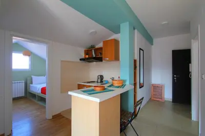a kitchen with a counter and a room with a bed at Lola Almost Home in Belgrade