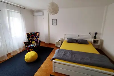 a bedroom with a yellow bed and a chair at FIVE in Belgrade