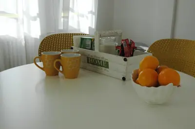 a table with a bowl of oranges and two cups at FIVE in Belgrade