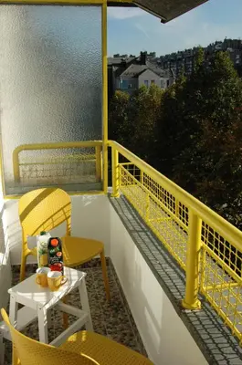 a balcony with a table and chairs on a yellow railing at FIVE in Belgrade