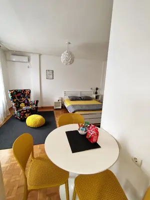 a room with a table and chairs and a bed at FIVE in Belgrade
