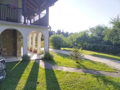 a porch of a house with a grass yard at Dunavski konaci in Brestovik