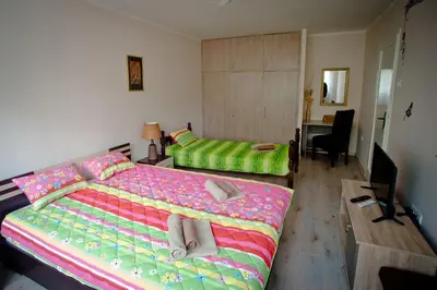 a bedroom with a large bed and a desk at Park Apartman in Arandjelovac