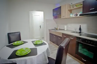 a kitchen with a table with green plates on it at Park Apartman in Arandjelovac