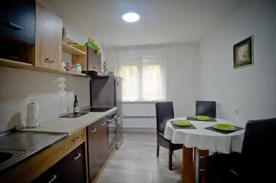 a kitchen with a table and a small table and chairs at Park Apartman in Arandjelovac