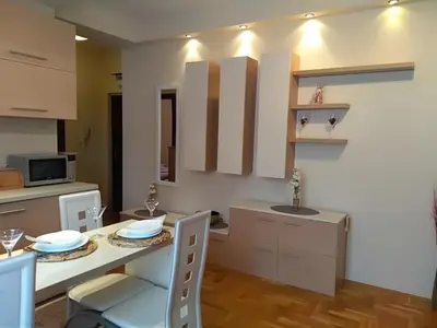 a kitchen with a table and a dining room at Apartman Nina Vojvode Stepe Vozdovac in Voždovac