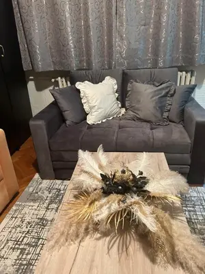 a living room with a grey couch with a table at Beo shooping centar in Belgrade