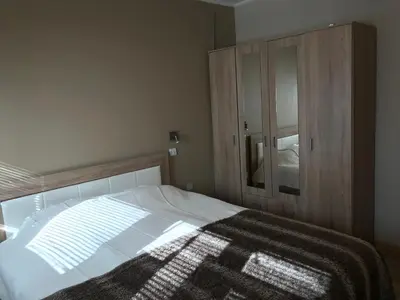 a bedroom with a bed and a wooden cabinet at Lovely Apartment 2 in Belgrade