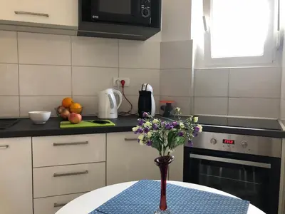 a kitchen with a table with a vase of flowers on it at La Fontana in Belgrade