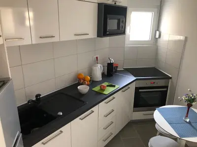 a kitchen with white cabinets and a black counter top at La Fontana in Belgrade