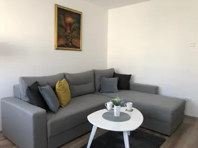 a living room with a gray couch and a white table at La Fontana in Belgrade