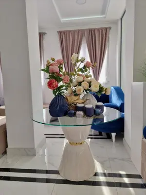 a glass table with a vase with flowers on it at ForS Resort & Spa in Belgrade