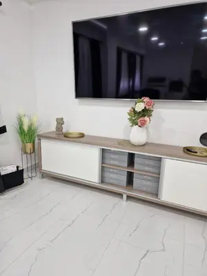 a living room with a television on a white wall at ForS Resort & Spa in Belgrade