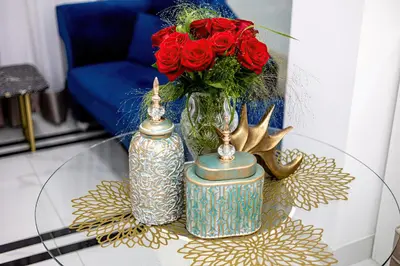 a glass table with two vases and a vase with red roses at ForS Resort & Spa in Belgrade