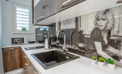 a kitchen with a sink with a woman painting on the wall at Casablanca apartment in Belgrade
