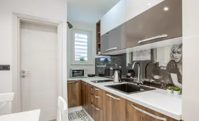 a kitchen with wooden cabinets and a sink at Casablanca apartment in Belgrade