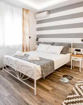 a bedroom with a bed with a striped wall at Casablanca apartment in Belgrade
