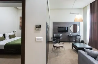 a hotel room with a bed and a desk at Hotel Grand Hedonist in Pančevo