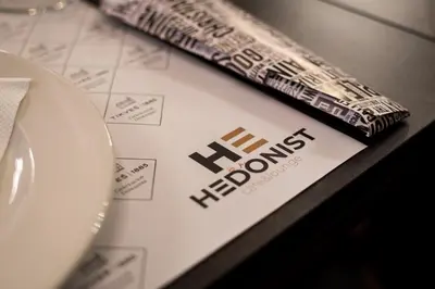a book with the hollywood sign on it next to a plate at Hotel Grand Hedonist in Pančevo