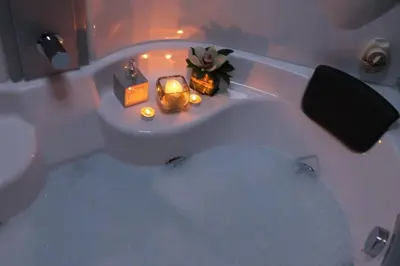 a bathroom with a bath tub with candles in it at Villa Skadarlija in Belgrade