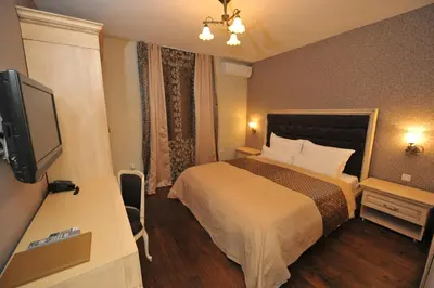 a hotel room with a bed and a flat screen tv at Villa Skadarlija in Belgrade