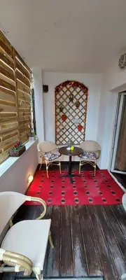 a room with a table and two chairs on a red rug at Villa Skadarlija in Belgrade