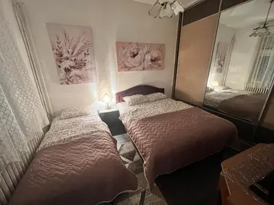 a bedroom with two beds and a mirror at Hardy's Apartment in Belgrade