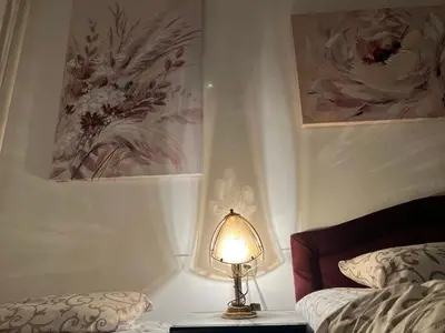 a lamp sitting on a table next to a bed at Hardy's Apartment in Belgrade