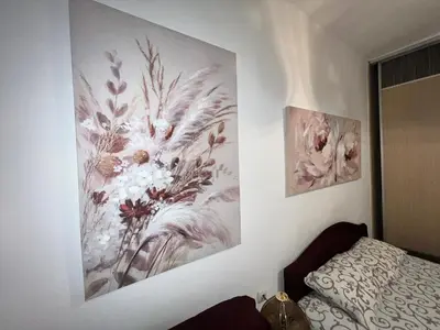 a bedroom with two pictures of flowers on the wall at Hardy's Apartment in Belgrade