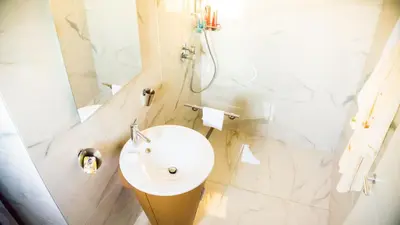 a white bathroom with a sink and a shower at LION NEST in Belgrade