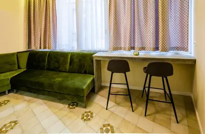 a living room with a green couch and two stools at Lux Villa Old Town in Belgrade