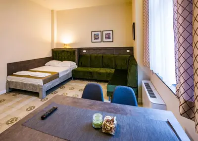 a room with a bed and a table and chairs at Lux Villa Old Town in Belgrade