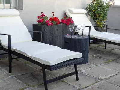 three wicker chairs sitting on a patio with flowers at Apartment New Belgrade Home in Belgrade
