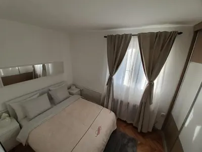 a small bedroom with a bed and a window at Apartment New Belgrade Home in Belgrade