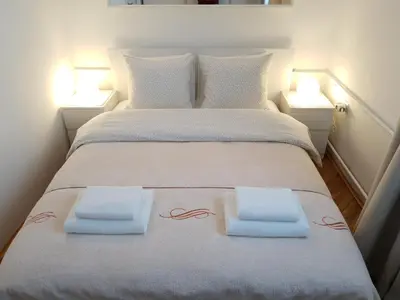 a large bed with two white pillows and two lights at Apartment New Belgrade Home in Belgrade