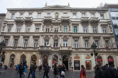 a large building with people walking in front of it at Knez Mihailova Apartman in Belgrade