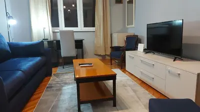 a living room with a couch and a tv at BY THE PARK free parking in Belgrade