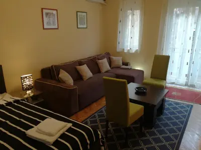 a living room with a couch and a table and chairs at BY THE PARK free parking in Belgrade