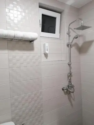 a bathroom with a shower with a window at Airport view Apartment in Belgrade