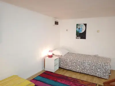 a small bedroom with a bed and a rug at Kiwi Apartment in Belgrade