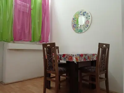 a table with two chairs and a plate on the wall at Kiwi Apartment in Belgrade