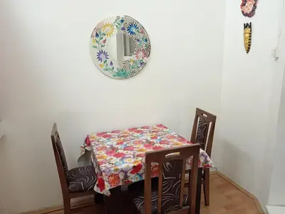 a table and chairs with a plate on the wall at Kiwi Apartment in Belgrade
