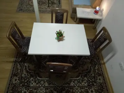 a white table and chairs with a plant on it at Tiki Apartmen in Belgrade