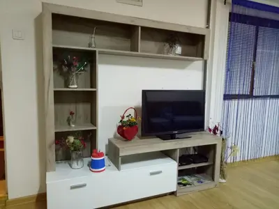 a living room with a tv on a white entertainment center at Tiki Apartmen in Belgrade