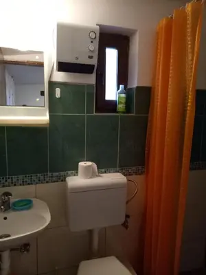 a bathroom with a toilet and a sink and a mirror at Tiki Apartmen in Belgrade