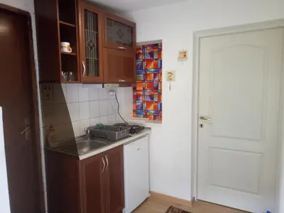 a small kitchen with a sink and a door at Tiki Apartmen in Belgrade