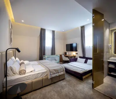 a hotel room with a bed and a desk at Maison Royale in Belgrade