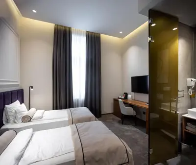 a hotel room with two beds and a desk at Maison Royale in Belgrade