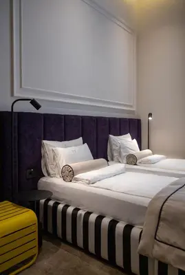 a bedroom with a large bed with a purple headboard at Maison Royale in Belgrade