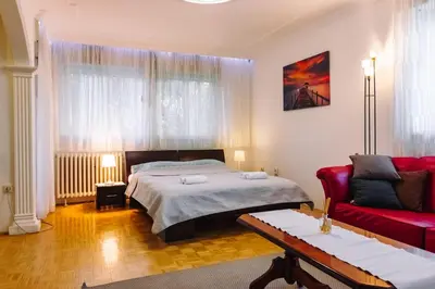 a bedroom with a bed and a red couch at Apartment Jasna in Belgrade